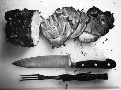 烤肉的灰度照片旁边的刀和叉
